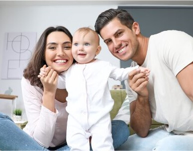 אבא, אמא וילד מסתכלים למצלמה ומחייכים